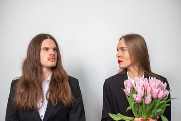 Elegant serious couple looking stright. Portrait of a man and a woman wearing black suits. White...