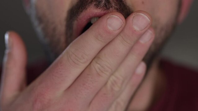 Close up of a lazy bored mouth, yawning in front of the camera. Causasian man. Exhaust employee, manager or worker. Frustration concept