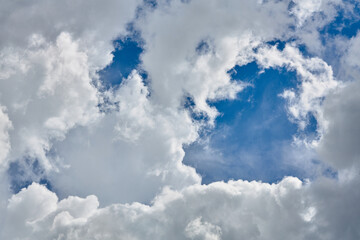 Naklejka na ściany i meble Cumulus clouds against a light blue sky with a clear fiber structure.