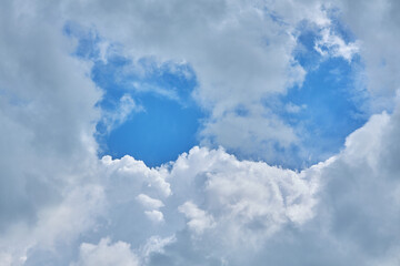 Cumulus clouds against a light blue sky with a clear fiber structure.