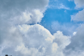 Cumulus clouds against a light blue sky with a clear fiber structure.