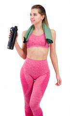 Fitness woman with athletic figure holding water or drink in her hand and a towel around her neck.Fit woman in pink sportswear isolated on white background showing her figure and smiling. In a pink