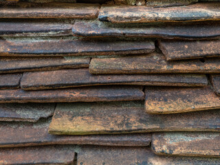 Background from the old tiled masonry. Orange tiles. Wall made of clay fragments. Wall texture.