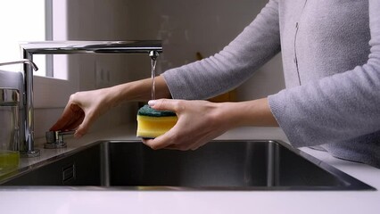 Woman cleaning dish with soap and sponge and rinsing it with water. Unrecognizable female doing dishes. 4k video. 