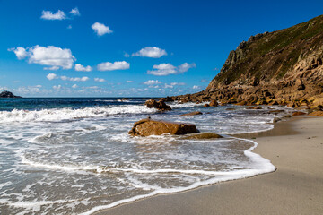 Waves lapping the sandy beach, at Porth Nanven in Cornwall