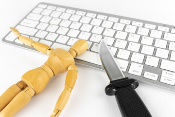 玩具のナイフとデッサン人形と、キーボード。犯罪予告のイメージ 