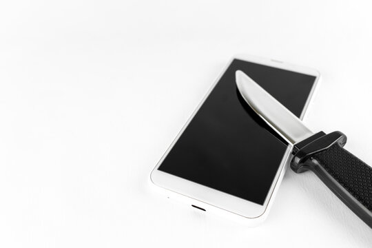 玩具のナイフと、スマートフォン。犯罪予告のイメージ