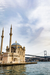 Fototapeta na wymiar Ortakoy Mosque and the Bosporus in Istanbul, Turkey. The Bosphorus Bridge, aka the 15 July Martyrs Bridge, is a famous landmark in Istanbul, Turkey