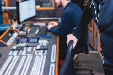 View of lighting technician operator working on mixing console workplace during live event concert...