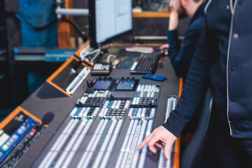 View of lighting technician operator working on mixing console workplace during live event concert...