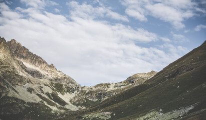 Mountain rocky pass and slopes with stone talus and vegetation, mountain landscape panorama