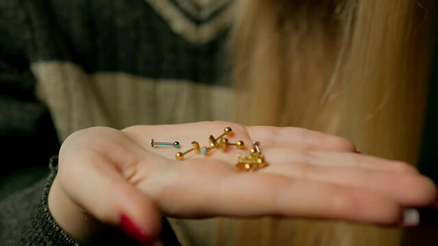 Woman chooses earring jewelry for ear piercing