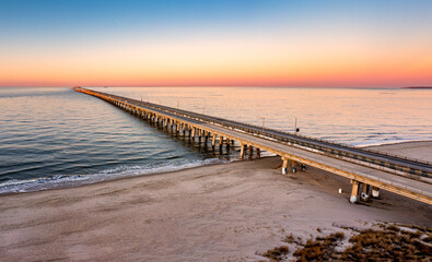 Aerial panorama of Chesapeake Bay Bridge Tunnel at sunset. CBBT is a 17.6-mile bridge tunnel that crosses the mouth of the Chesapeake Bay. - 577840687