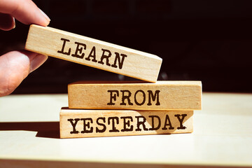 Wooden blocks with words 'Learn from yesterday'.