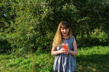 Smiling young woman drinking fresh lemonade with a straw. Concept of health, relax and lifestyle for people
