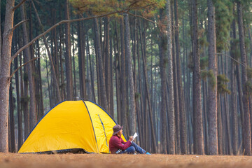 Solo overnight camping while sitting beside tent at campsite in the pine forest while writing...