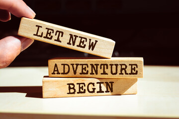 Wooden blocks with words 'Let new adventure begin'.
