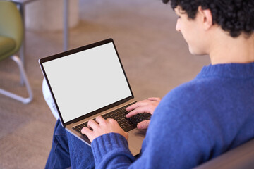 Overhead view of a man, developer programmer using laptop with white blank screen with free ad space