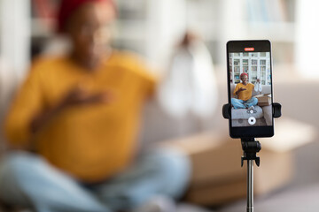 Selective focus on smartphone recording black woman blogger