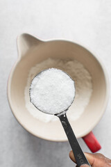 Fototapeta na wymiar Top view of White sugar in a measuring cup, granulated sugar for baking, white sugar in a measuring cup