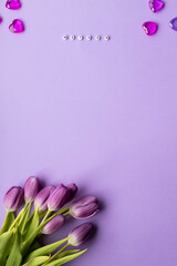 Spring tulip and text mother on english laid out of multi-colored cube on violet background