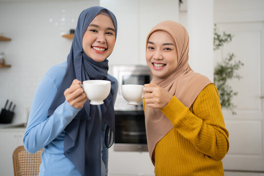 Multiracial colleagues talk during lunch break in office kitchen.