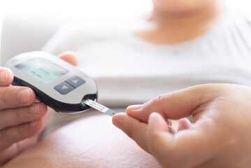 Pregnant woman using insulin test on pregnancy time