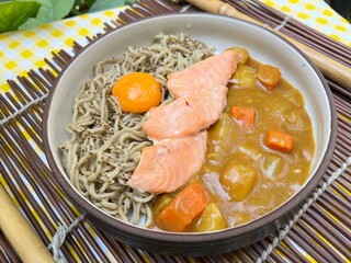 Salmon spinach nooddle with curry sauce and yolk on top