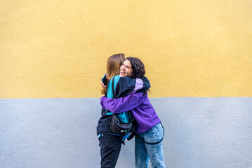 Young friends hugging outdoors on the street.