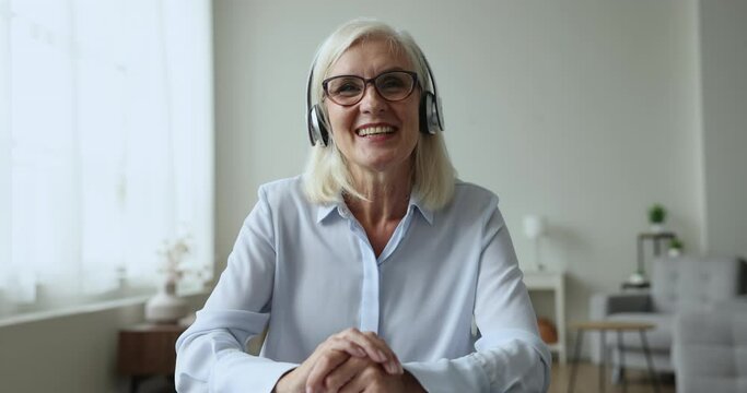Mature female, certified psychologist gives support, provide professional help to client remotely wear headphones looks at camera talk, use video call app. Workflow of psychological on-line counsellor