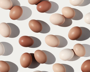 Neutral painted Easter eggs beige brown color gradient on white background, dark shadow at sunlight. Aesthetic flat lay from Chicken eggs, Easter holiday food pattern, top view