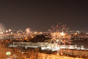 Fototapeta premium Fireworks in the city at night during New Year or other holidays celebration. Soft focus background