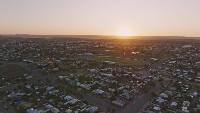 Early morning sunrise high angle aerial drone footage of the historic outback mining town of Broken Hill, New South Wales, Australia. Flying over residential and business districts. Shot in 60 fps.