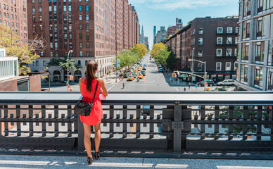 New york City lifestyle. Young professional woman in cute dress standing on New York High Line Park...
