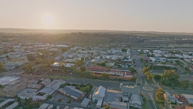 Early morning sunrise high angle aerial drone footage of the historic outback mining town of Broken Hill, New South Wales, Australia. Flying over residential and business districts. Shot in 60 fps.