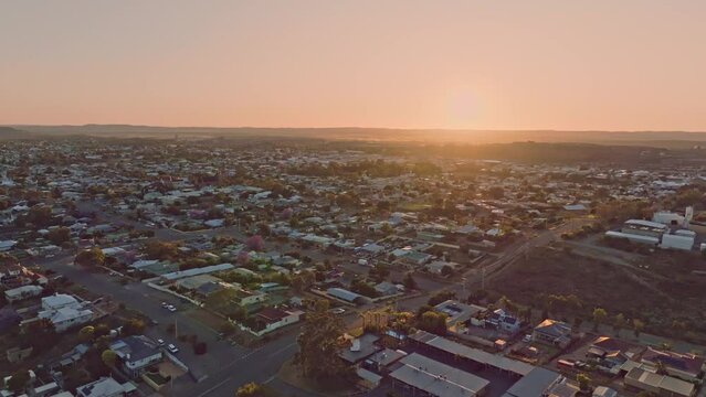 Early morning sunrise high angle aerial drone footage of the historic outback mining town of Broken Hill, New South Wales, Australia. Flying over residential and business districts. Shot in 60 fps.