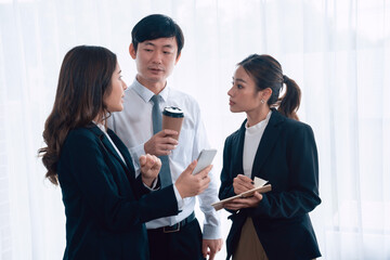 Mentor, manager with coffee advice younger colleagues in workplace. Businesspeople discussing or...