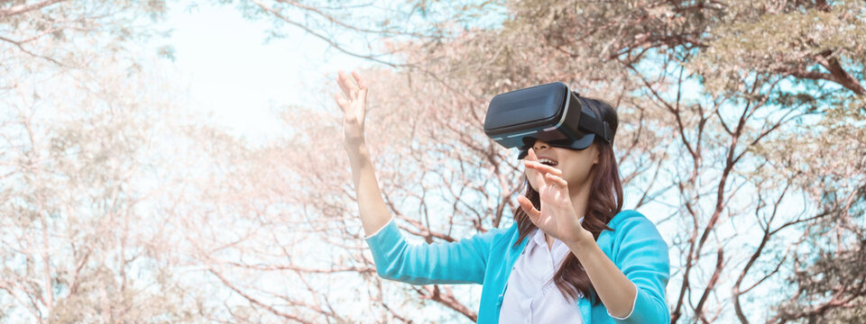 young asian girl using vr headset for relax in garden. For banner design. - Powered by Adobe
