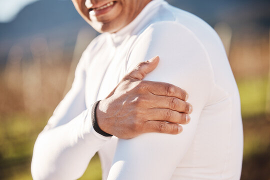 Hand, shoulder and injury with a runner man outdoor for cardio or endurance exercise in nature. Pain, arm and emergency with a male athlete suffering from cramp after an accident while running