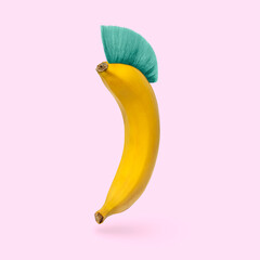 Humor is a cheerful banana with a mohawk hairstyle on a pink background. Minimal concept of humor...