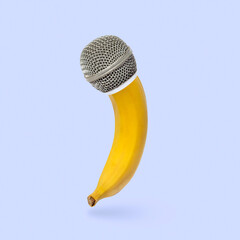 Playful banana with microphone. Minimal idea of fruit, healthy food, sound, music and audio podcast. High quality photo