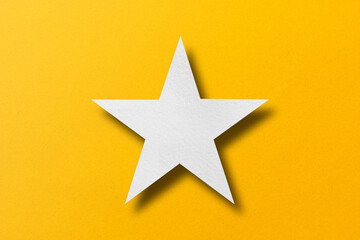 paper cut star shape with light and shadow placed on a yellow paper background