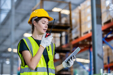 women engineer holding walkie talkie and tablet quality control standing at machine of factory...