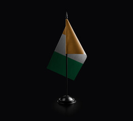 Small national flag of the Cote dIvoire on a black background