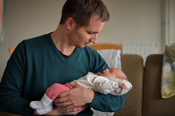 Portrait of man holding newborn baby girl