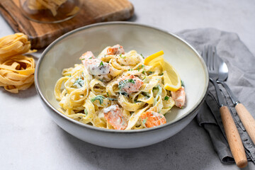 Italian made fettuccine pasta with creamy sauce and grilled salmon. - 577902485