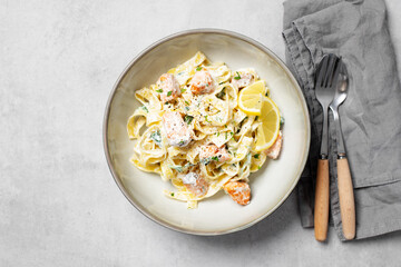 Italian made fettuccine pasta with creamy sauce and grilled salmon. top view