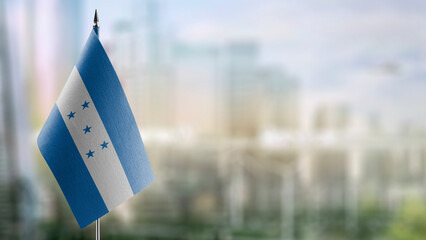 Small flags of the Honduras on an abstract blurry background