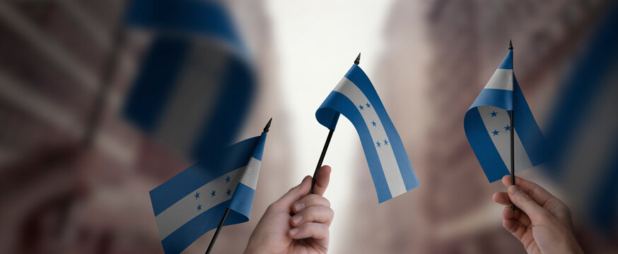 A group of people holding small flags of the Honduras in their hands