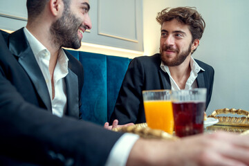 Young men enjoying breakfast and conversation in a restaurant - Breakfast and conversation at a cafe